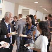 Networking event with people talking huddled in group