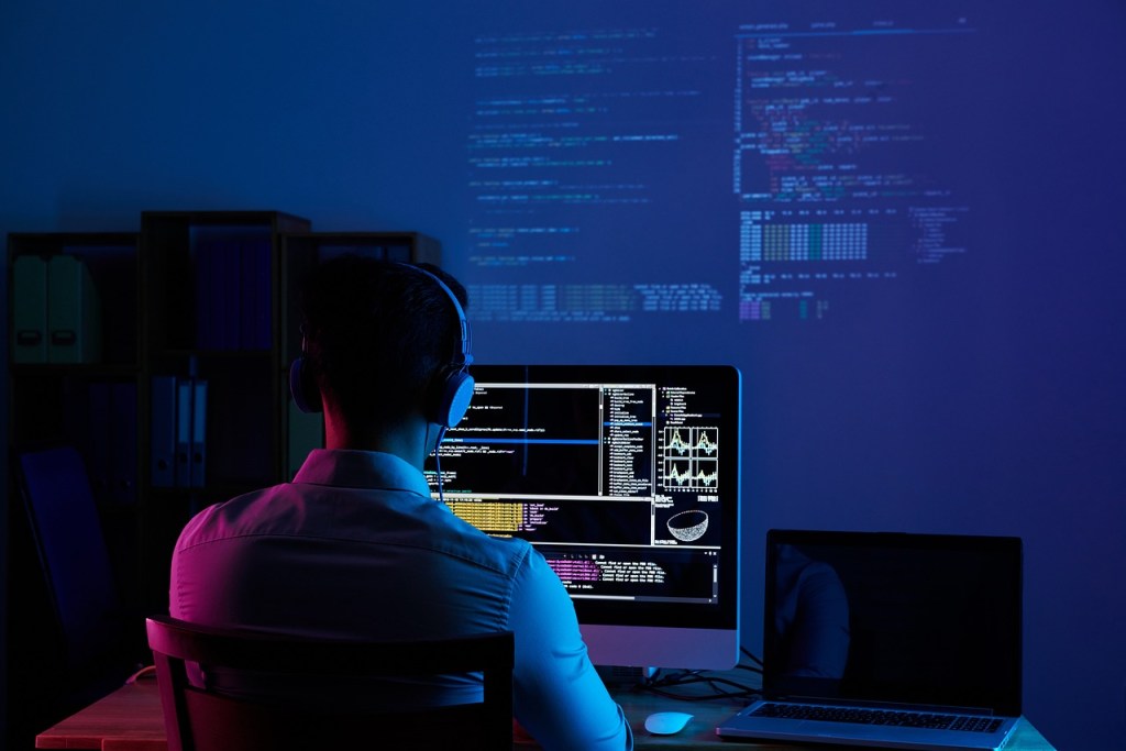 Software Developer sitting in a dark blue room