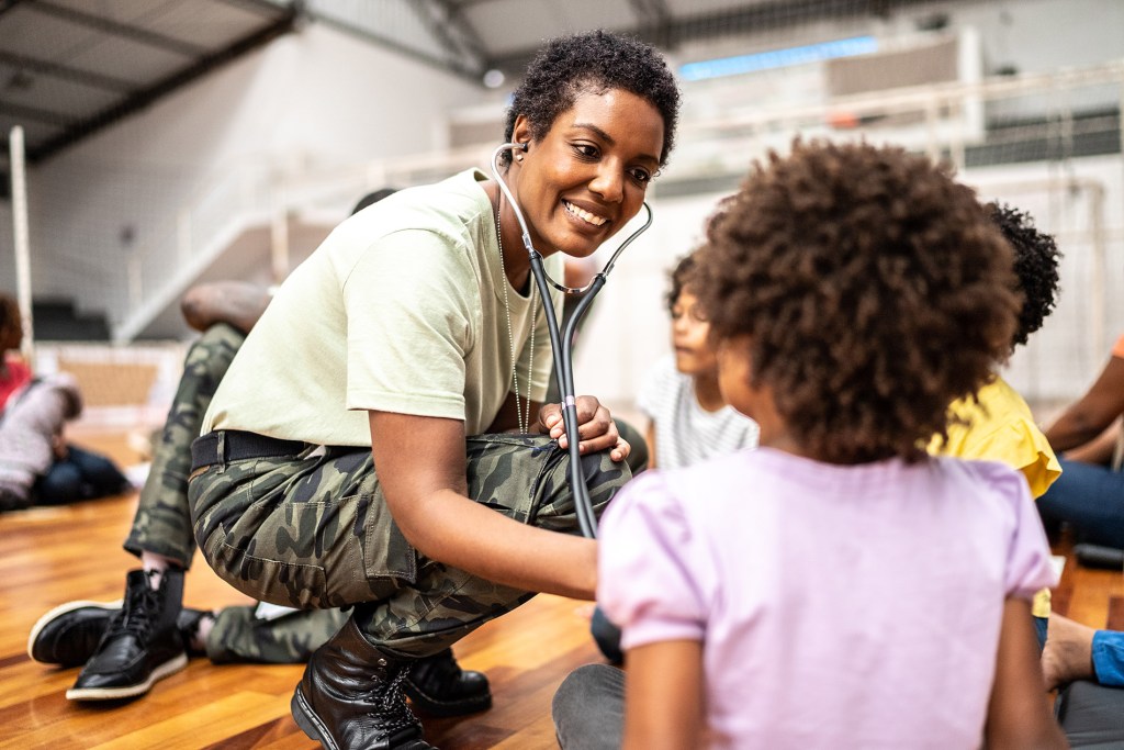 Army doctor examining refugee children